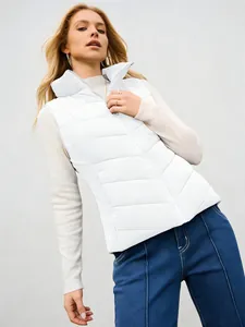 Detail view of a white quilted stand collar puffer vest worn by a blonde female model