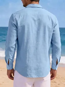 Back view of a men's light blue long sleeve cotton linen shirt on a sunny beach