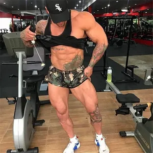 Athlète masculin portant un short de fitness camouflage dans une salle de sport moderne