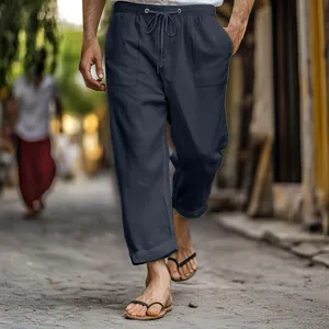 Close-up of men's navy linen pants featuring elastic drawstring waist and side pockets.