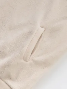 Close-up macro view showing the pocket and fabric detail of beige men's fleece sweatshirt