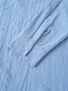 Detalle del puño y botones de una camisa de lino y algodón azul claro para hombre