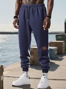 Vista detallada de pantalones jogger azul marino para hombre con forro polar en un modelo.