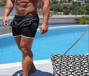 Gros plan d'un mannequin portant un short de sport noir avec bordure blanche à la piscine