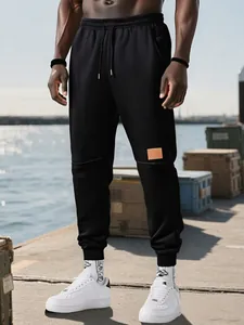 Pantalones deportivos de forro polar negro para hombre con zapatillas blancas al aire