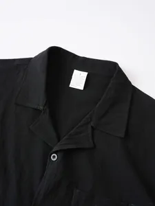 Detalle del cuello y la textura de la tela de una camisa de lino negro para hombre