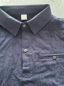 Close-up of navy blue cotton linen shirt featuring a collar and vintage wooden buttons