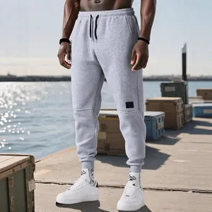 Pantalones de chándal grises ajustados para hombre con cordón en un entorno portuario