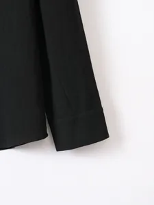 Detailed close-up view of black cotton linen shirt sleeve cuff and hem with fine texture