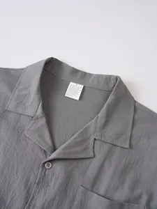 Primer plano del cuello de una camisa de lino gris con talla S y etiqueta