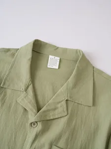 Close-up of sage green retro linen shirt collar with size S tag showing material details