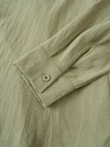 Detailed macro view showing the cuff and button of a men's sage green cotton linen shirt
