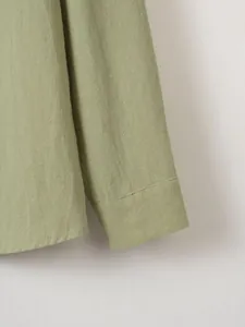 Close-up detail of the sleeve cuff on a sage green cotton linen casual shirt.