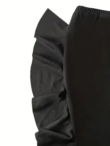 Detailed macro view showing the elastic waistband and side ruffle of a black knit skirt