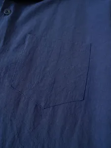 Detalle de cerca del bolsillo de una camisa vintage de lino y algodón azul marino