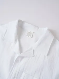 Vista detallada de camisa casual de lino blanco para hombre con cuello y textura