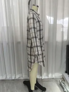Side view detail of a long-sleeved plaid shirt dress with a stylish high-low hemline