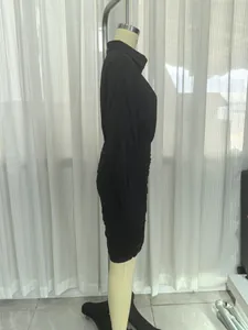 Elegante abito a camicia nero con risvolto e gonna arricciata vista di profilo