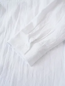 Primer plano del puño de una camisa blanca de algodón y lino con detalle de botón