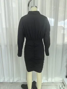 Vista posteriore di un elegante abito a camicia nero arricciato a maniche lunghe