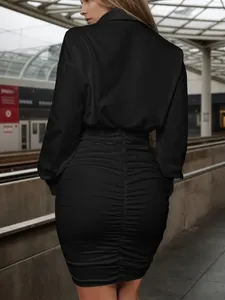 Vista ravvicinata di un elegante abito a camicia nero con gonna aderente arricciata