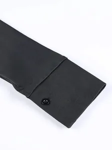 Vista dettagliata del polsino di un elegante abito a camicia nero con chiusura a bottone.