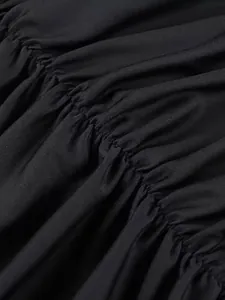 Primo piano della texture arricciata elastica su un elegante tubino nero dettaglio.