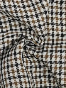 Close-up detail of high-quality brown and black houndstooth checkered fabric texture.