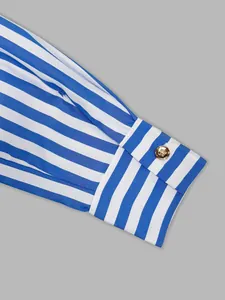 Close-up detail of blue and white striped shirt cuff featuring an elegant gold button