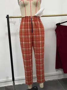 Detail der hoch taillierten orangefarbenen karierten Hose mit rundem Frontreißverschluss