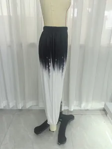 Detailed side view showing black to white gradient effect on loose knit sweatpants
