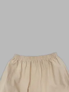 Detailopname van de elastische tailleband van een beige linnen harembroek voor dames.
