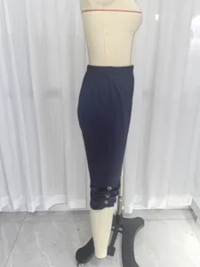 Seitenprofil einer dunkelblauen Caprihose mit modischen Knopfsdetails am unteren Saum.