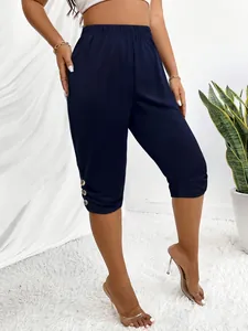 Nahaufnahme der dunkelblauen Damen-Caprihose mit seitlichem Knopfdesign am Bein.