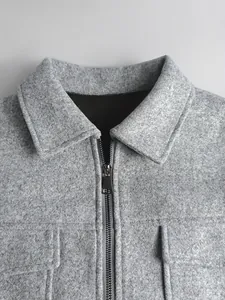 Détail de la texture en laine grise avec fermeture éclair métallique et col de veste
