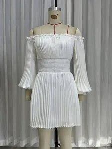 Détail d'une robe plissée blanche à épaules dénudées avec une taille élastique smockée.