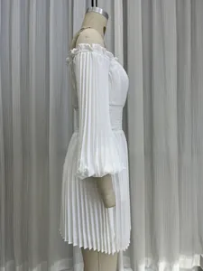 Vue latérale d'une robe blanche plissée à épaules dénudées avec taille smockée