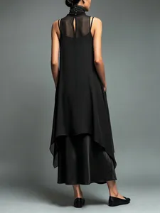 Back view of a black layered dress set featuring mesh stitching and a high collar.