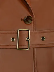 Primer plano de una chaqueta de cuero PU marrón con hebilla de cinturón de latón vintage