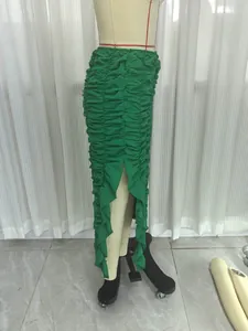 Green ruched asymmetrical maxi skirt with ruffle trim and high-low hem design.