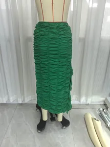 Detailed view of emerald green ruched midi skirt with asymmetrical ruffled hemline