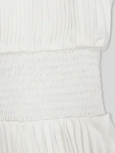 Gros plan sur le détail de la taille smockée blanche d'une robe française plissée d'été