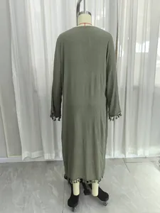 Detailed back view of an olive green long sleeve maxi cover-up with tassel fringe trim.