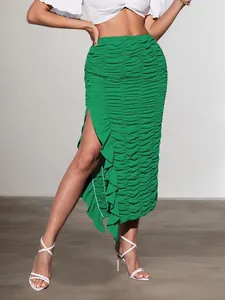 Detailed view of women's green ruched midi skirt featuring ruffle trim and side slit.