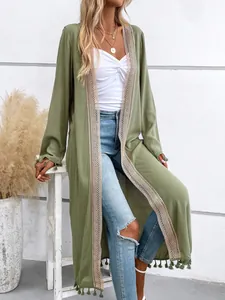 Detail of olive green long cardigan featuring intricate lace trim and tassel fringe