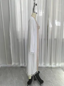 Detailed side view of white long-sleeved beach cover-up with tassel lace trim