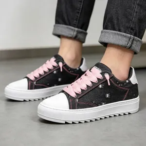 Primer plano de zapatillas de plataforma de mezclilla negra con cordones rosas y suela