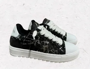 Vista detallada de las zapatillas negras NUMERIS con moteado plateado y suela blanca gruesa