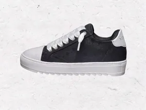 Detalle de las zapatillas NUMERIS blancas y negras con suela gruesa y cordones blancos