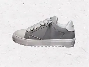Detalle de las zapatillas casuales en gris y blanco con suelas gruesas blancas y cordones.
